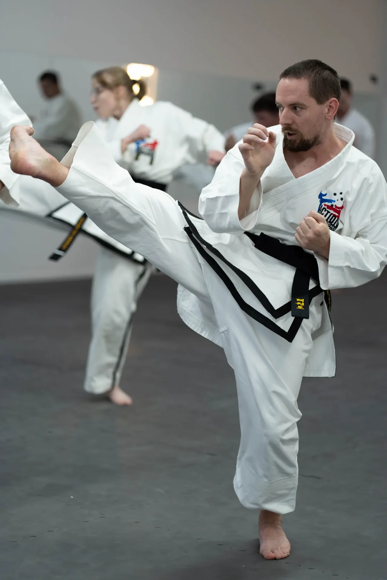 Black belt instructor executing a high side kick during self defence training at Action Tae Kwon-Do Canberra